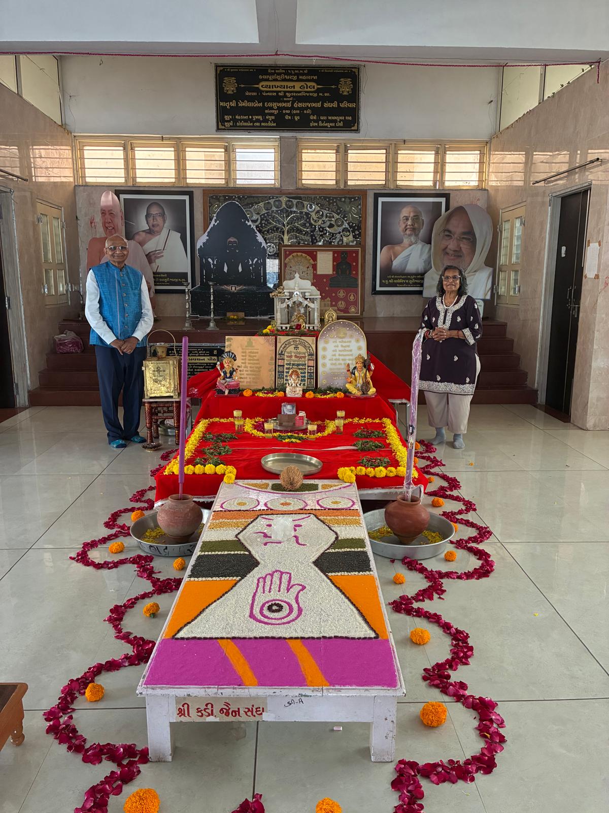 Harsha and Jay Patel standing beside a decorated Namokar Jaap altar